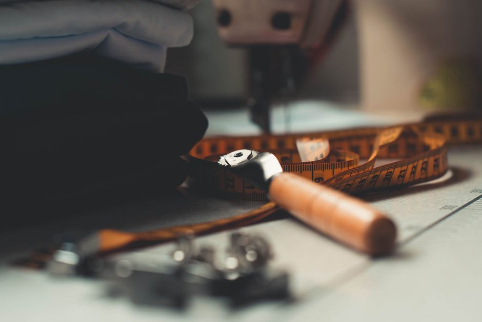 A detailed image of tailoring tools and fabrics on a workbench, perfect for sewing concepts.